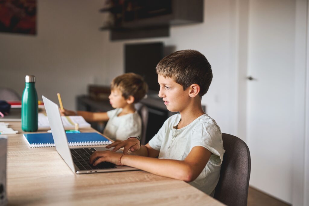 Dos niños aprendiendo y estudiando con el ordenador.