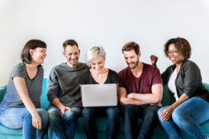 Tres mujeres y dos hombres de mediana edad mirando al ordenador
