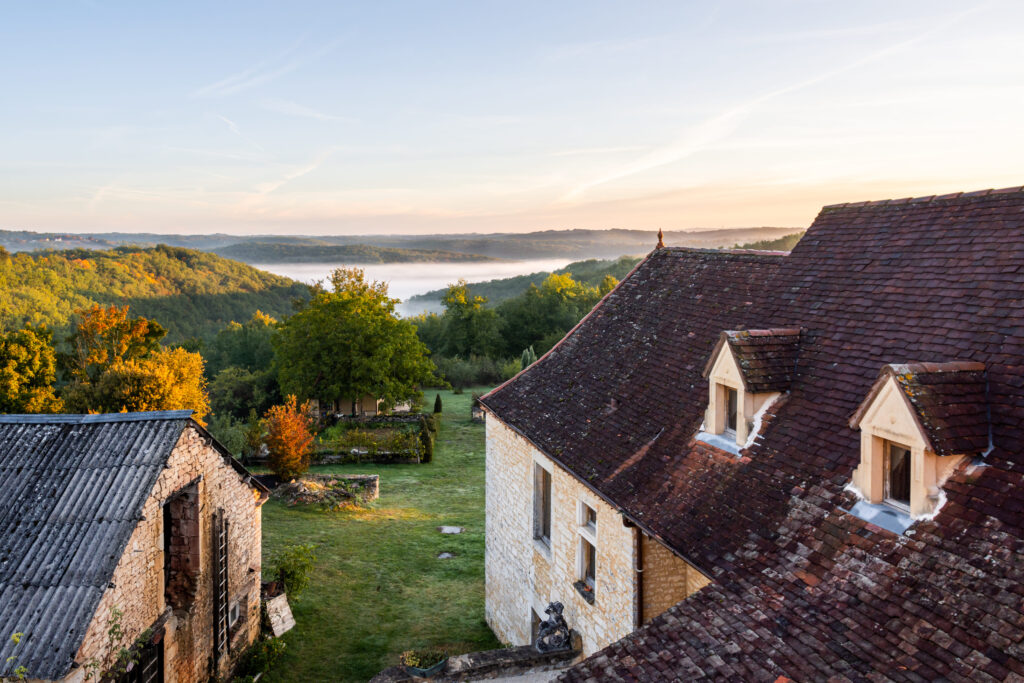 Paisaje de una casa en el campo con un lago en el fondo