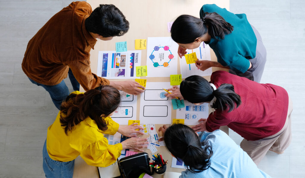 6 personas planificando con hojas en la mesa