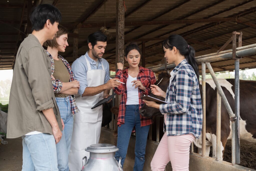 Tres mujeres y dos hombres hablando mientras sujetan tablets en una granja