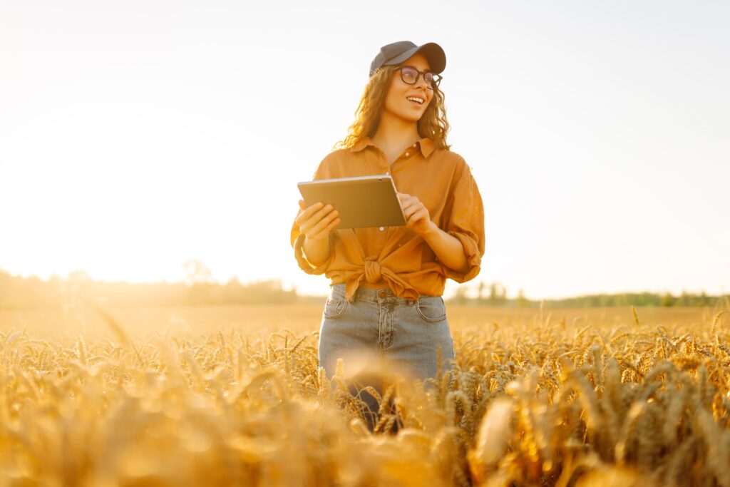 Mujer con gorra sujetando una tablet en el campo