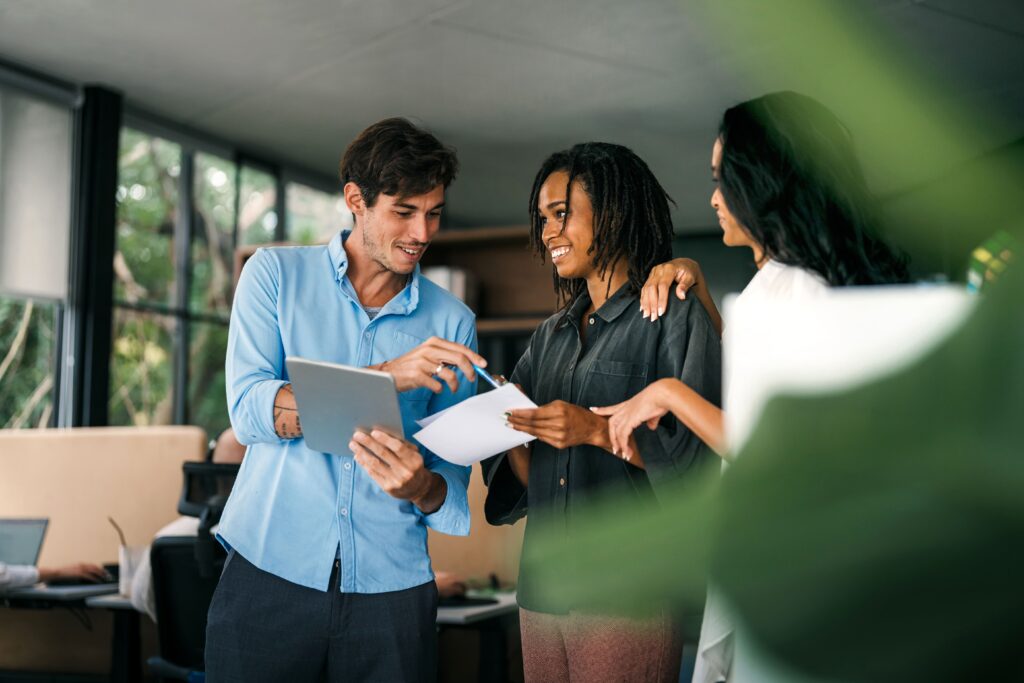 Dos chica sy un chico hablando mientras miran sus tablets