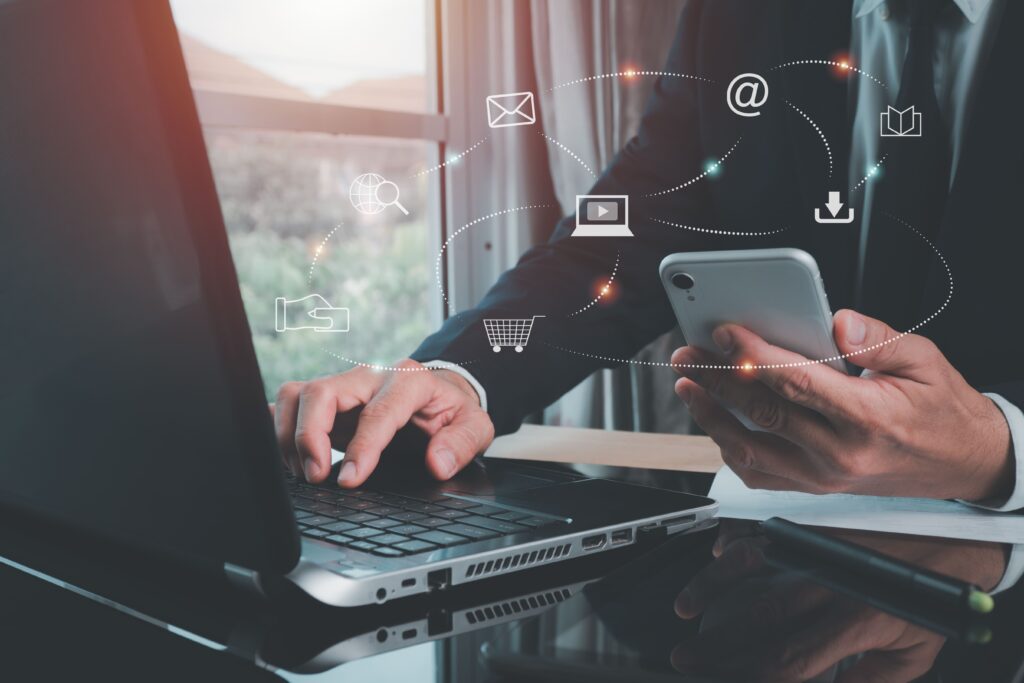 Hombre mirando la pantalla del ordenador con una tarjeta en la mano