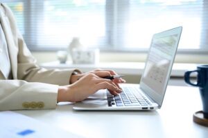 Manos de persona joven escribiendo en un portátil