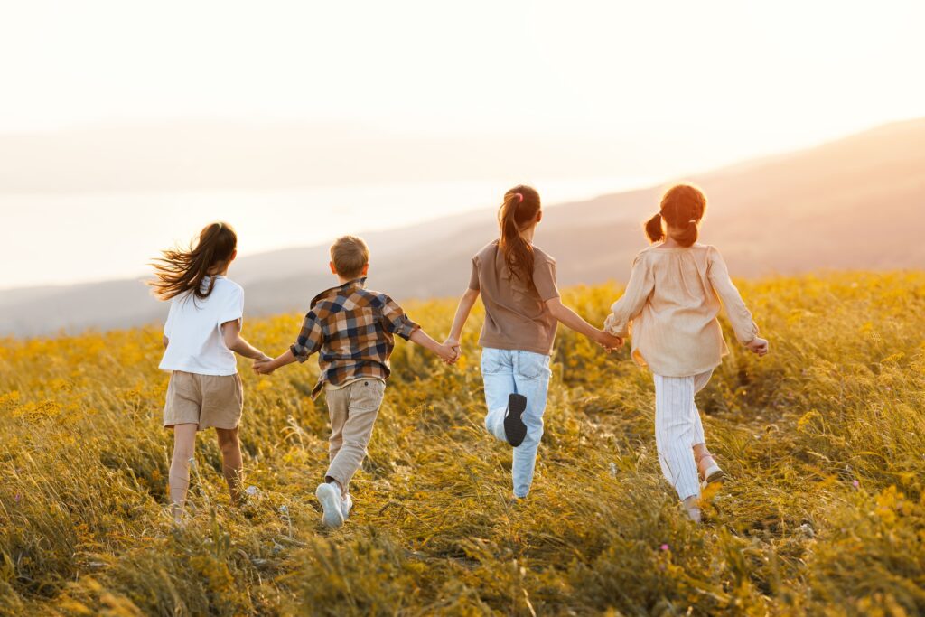 4 niños corriendo por el campo