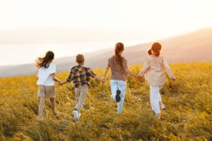 4 niños corriendo por el campo