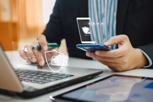 Persona con un portátil y un móvil haciendo la verificación de dos pasos